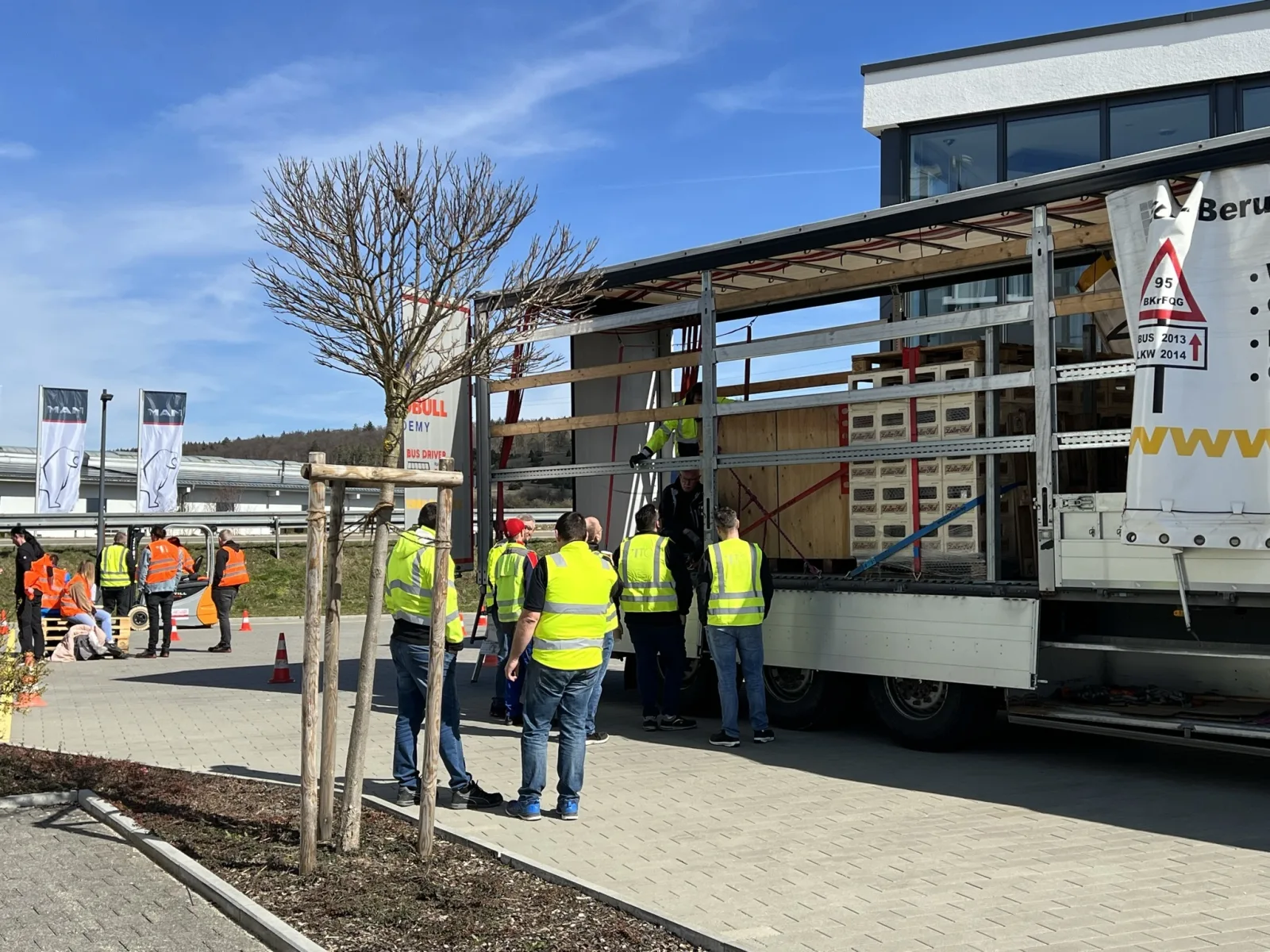 Ladungssicherungsbeauftragter und mehrere Personen sichern Ladung